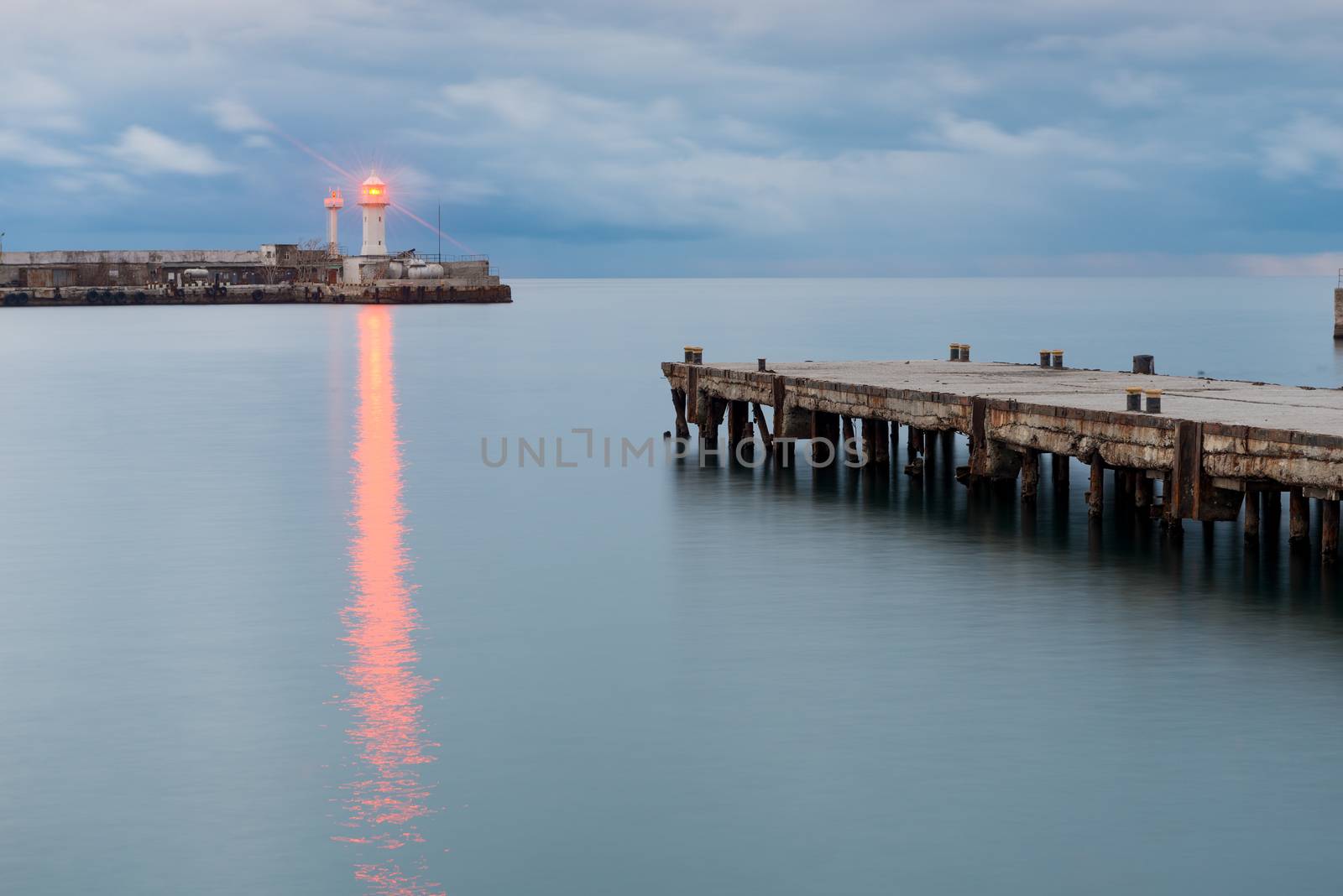 The bright light of the lighthouse on the seashore, right in the by kosmsos111