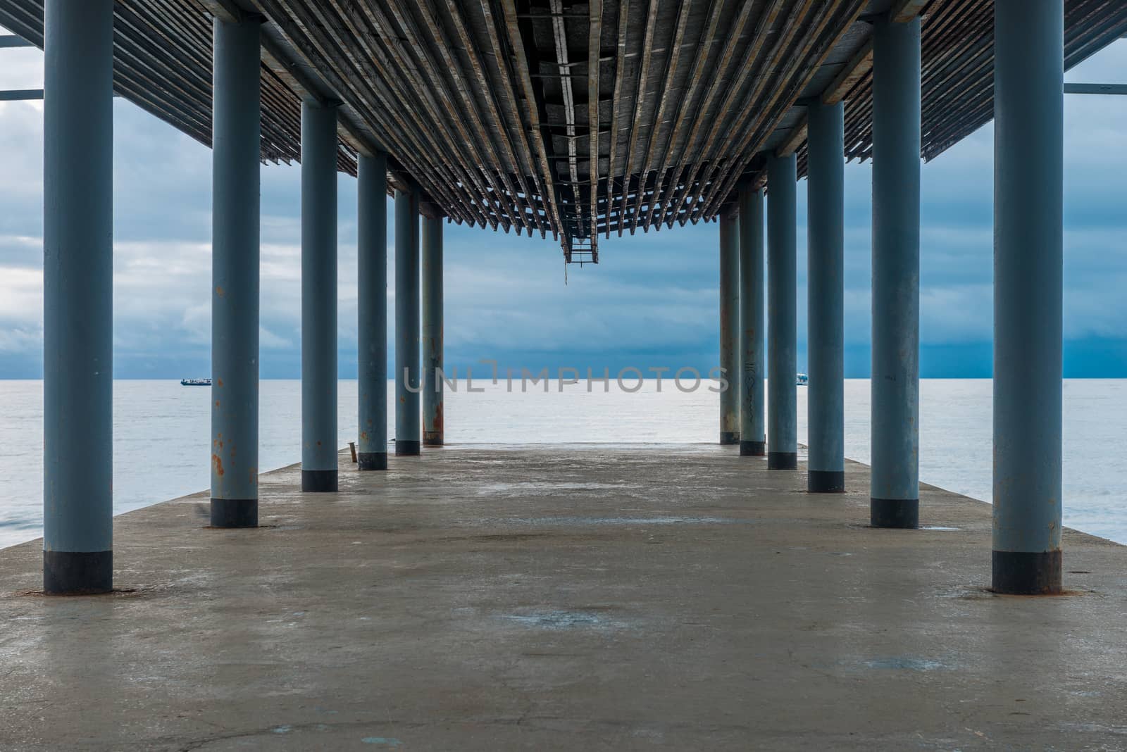 Pier under a canopy, a view of the sea and the gloomy autumn sky