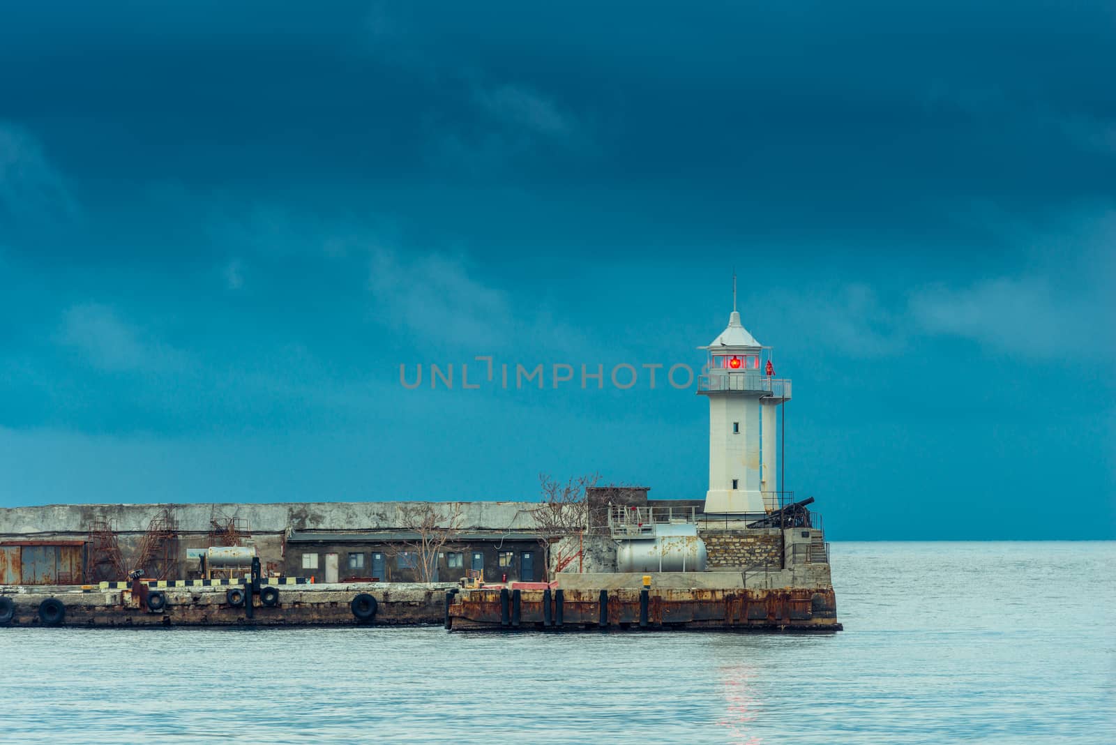 Horizontal photo of a lighthouse with a red lantern on the backg by kosmsos111