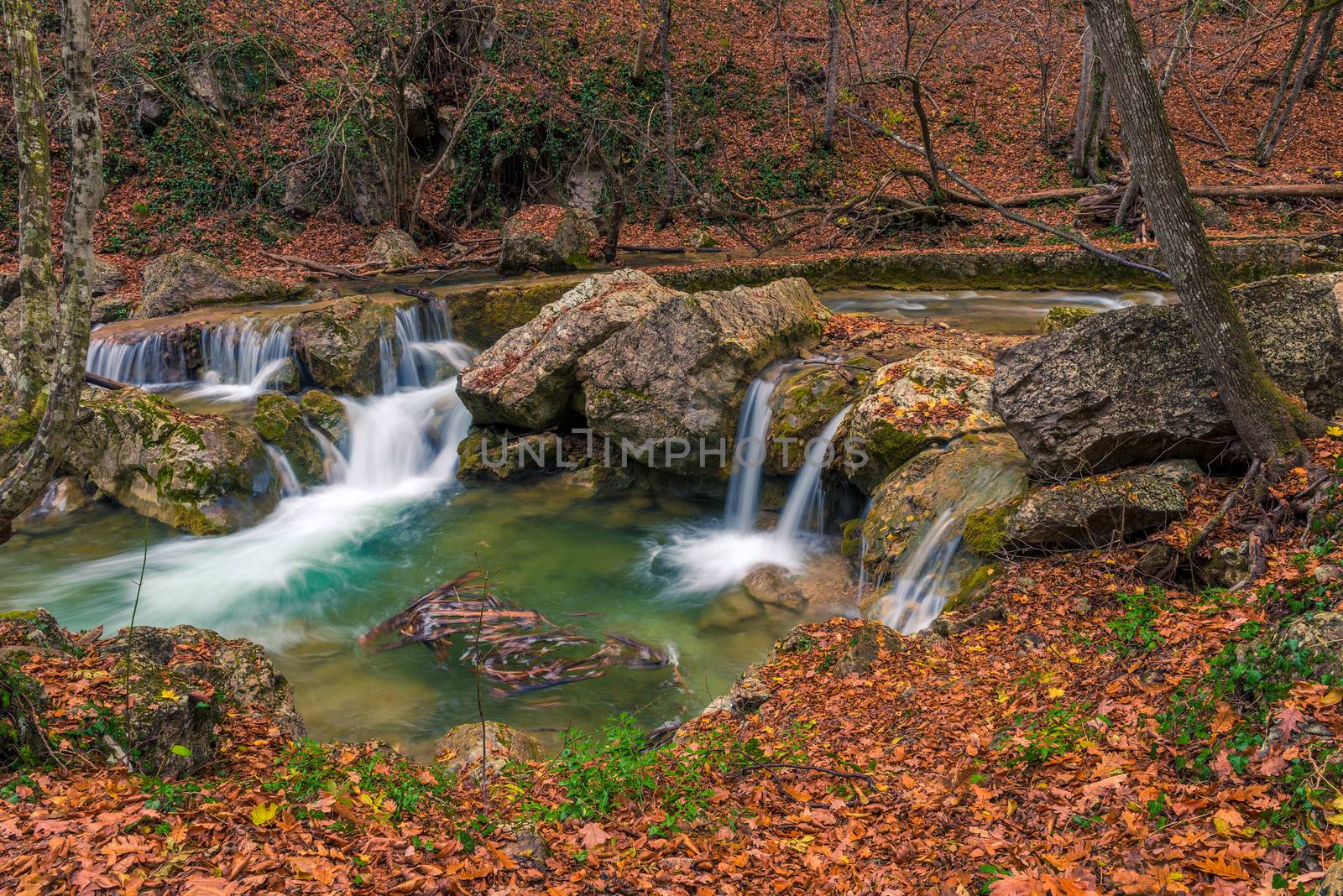 small waterfalls and a river postcard view in a beautiful natural location in the autumn mountain forest