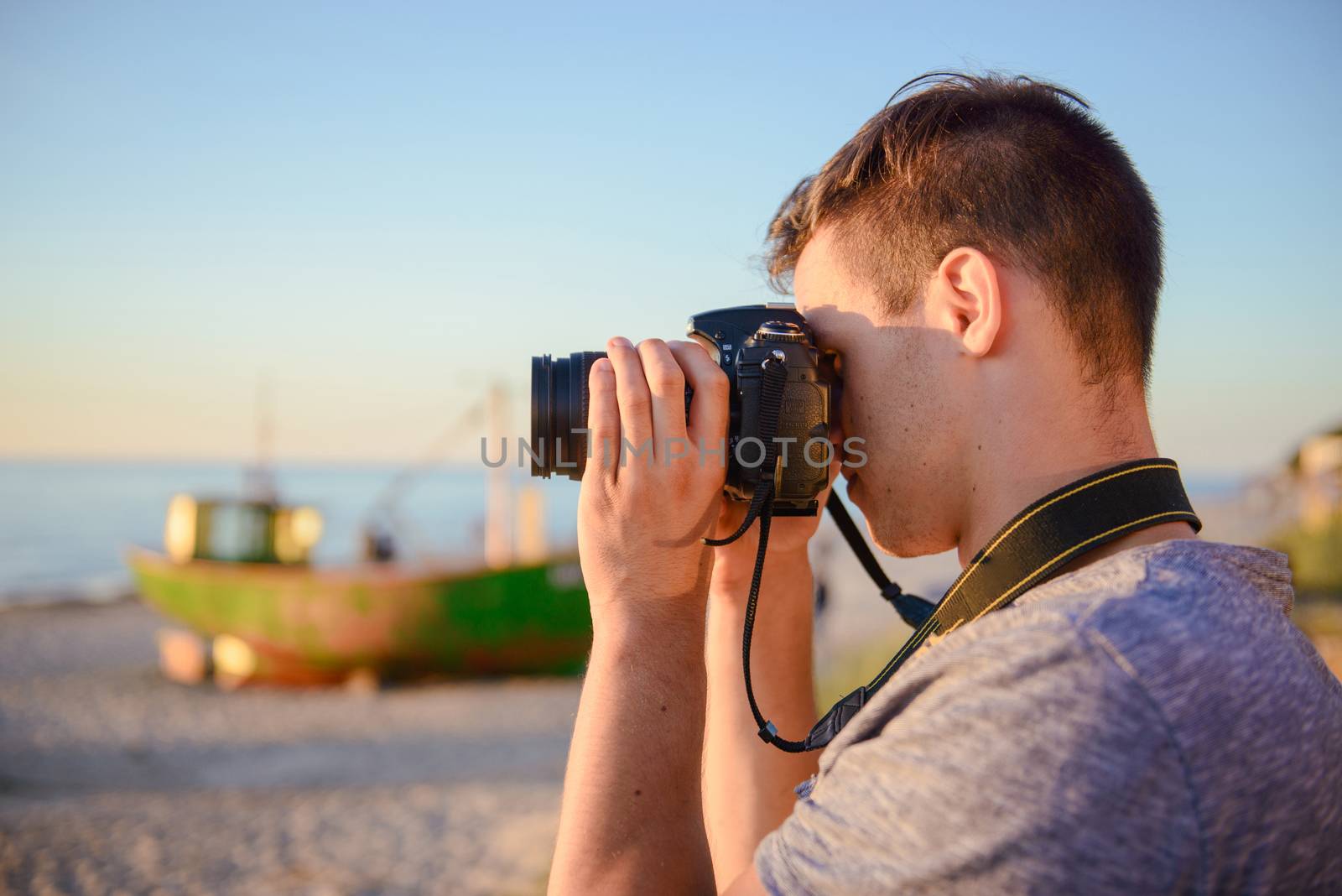 Silhouette of young photographer on the beach. Summer time