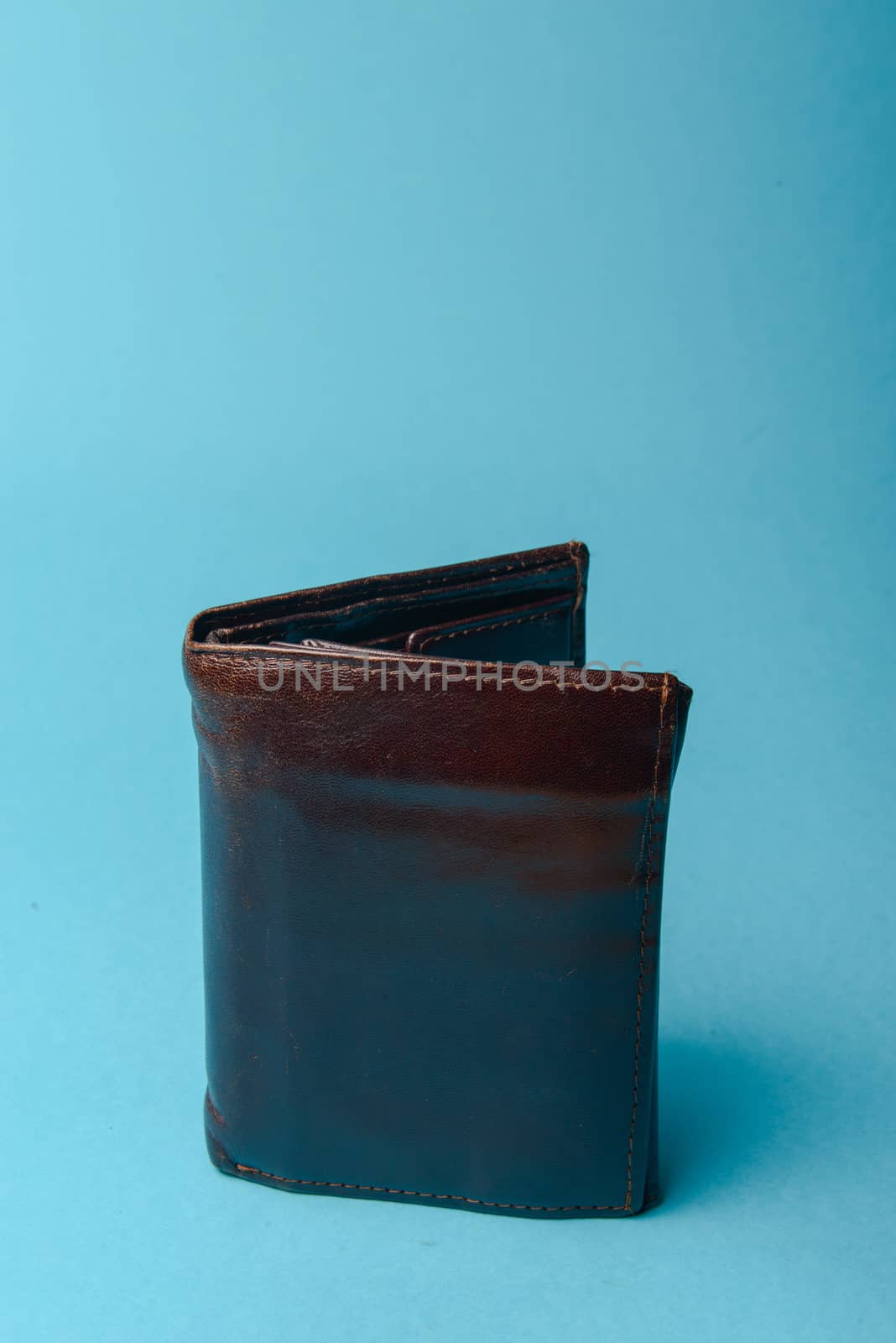 brown mans leather wallet on a blue background