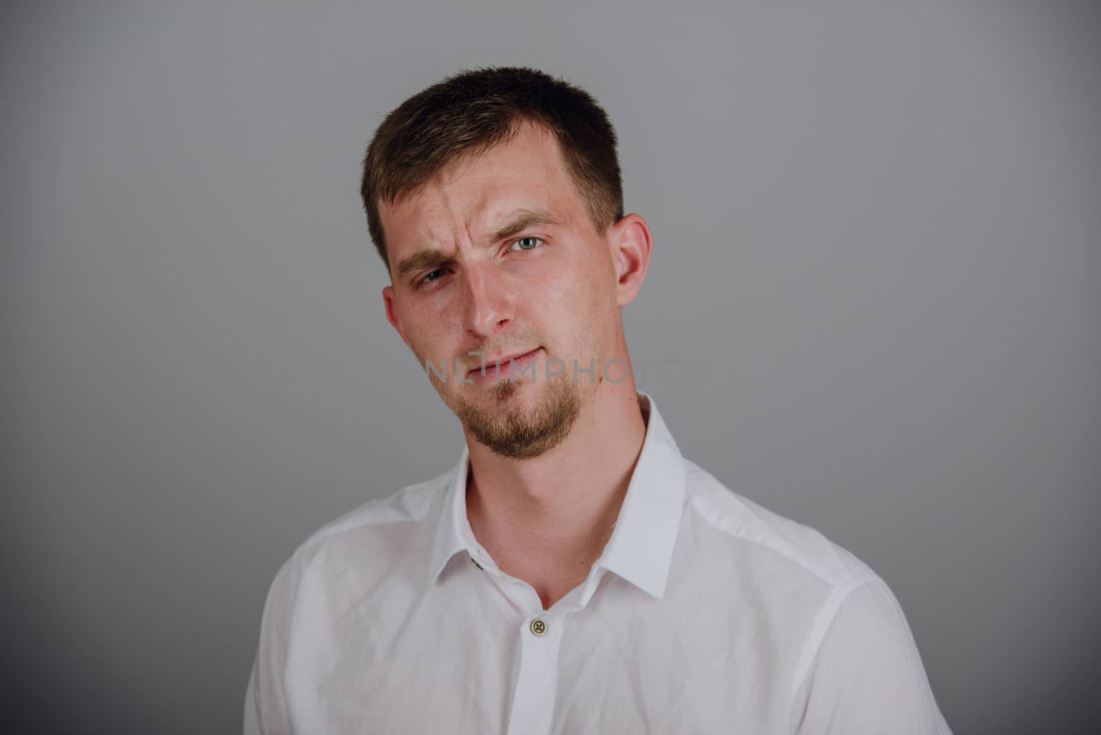 Portrait of a smiling young brunette man in studio