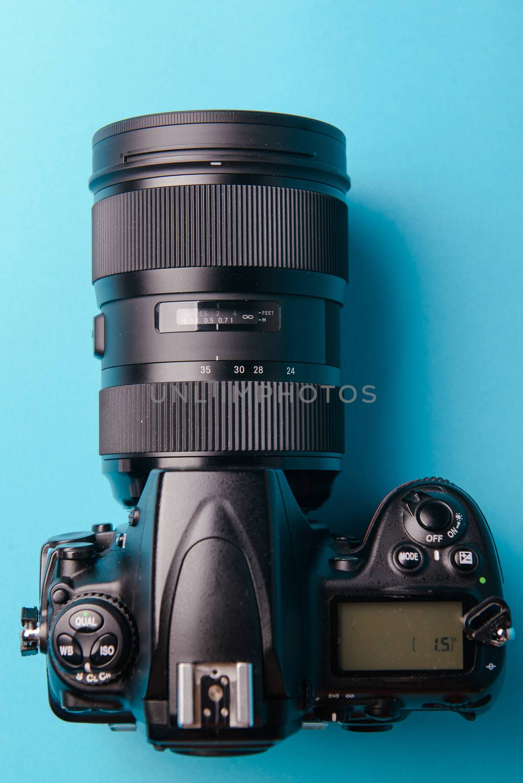 Professional modern DSLR camera against blue background