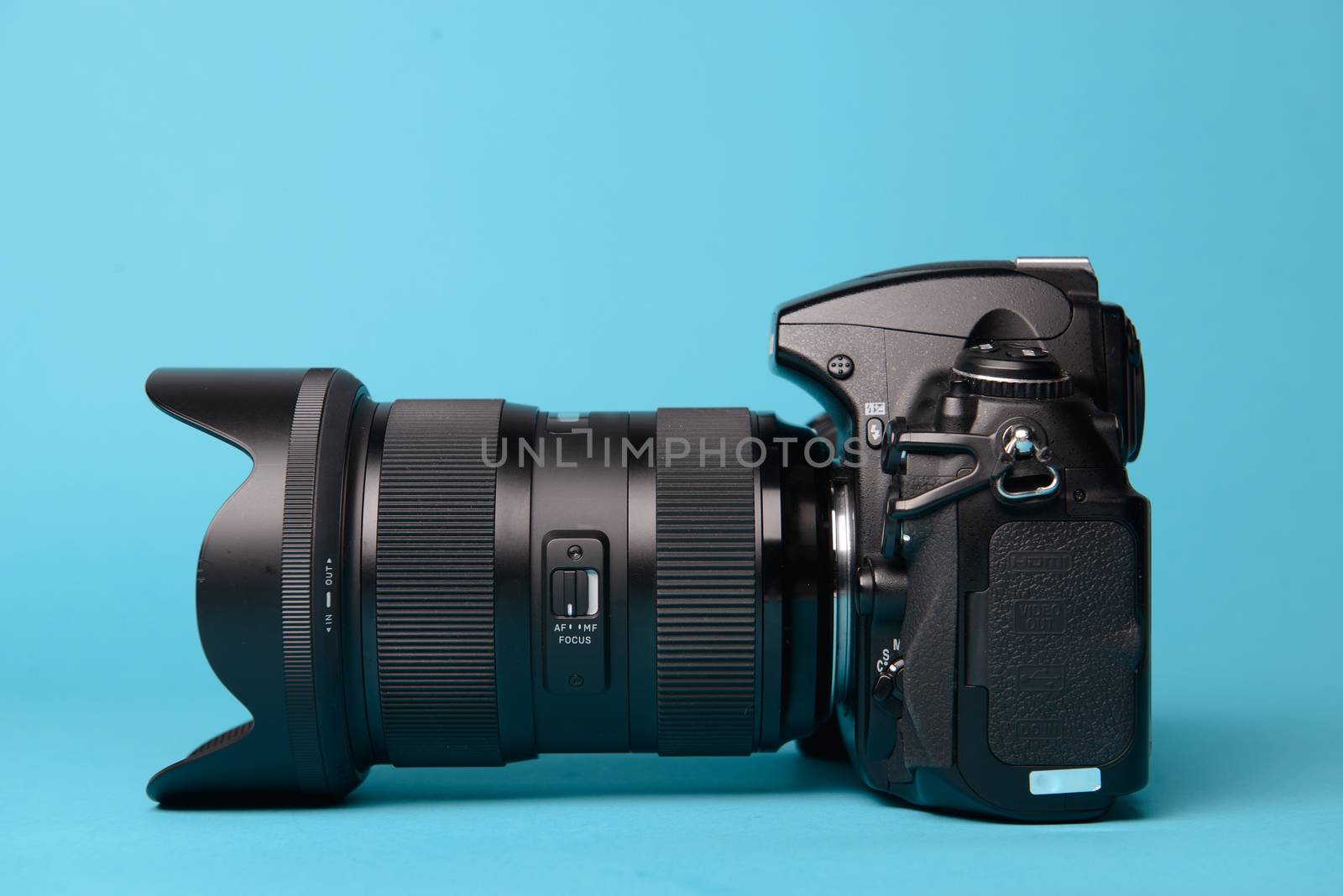 Professional modern DSLR camera against blue background