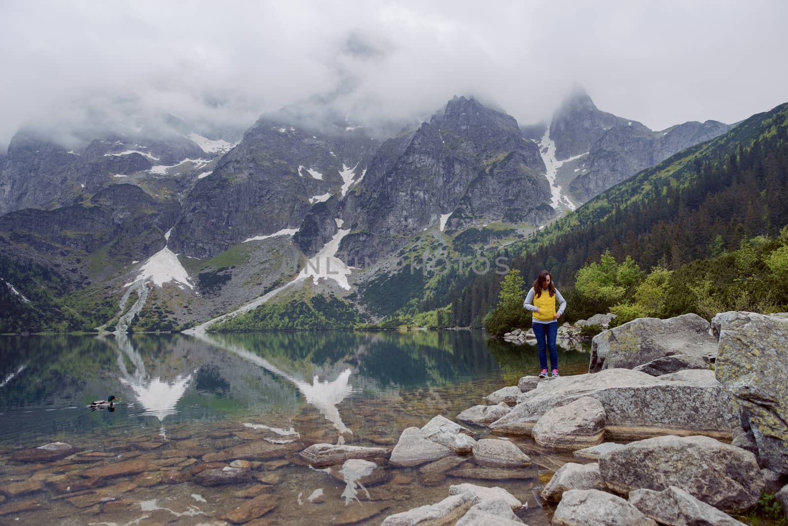 woman relaxing on the lake and mountains sunny landscape.