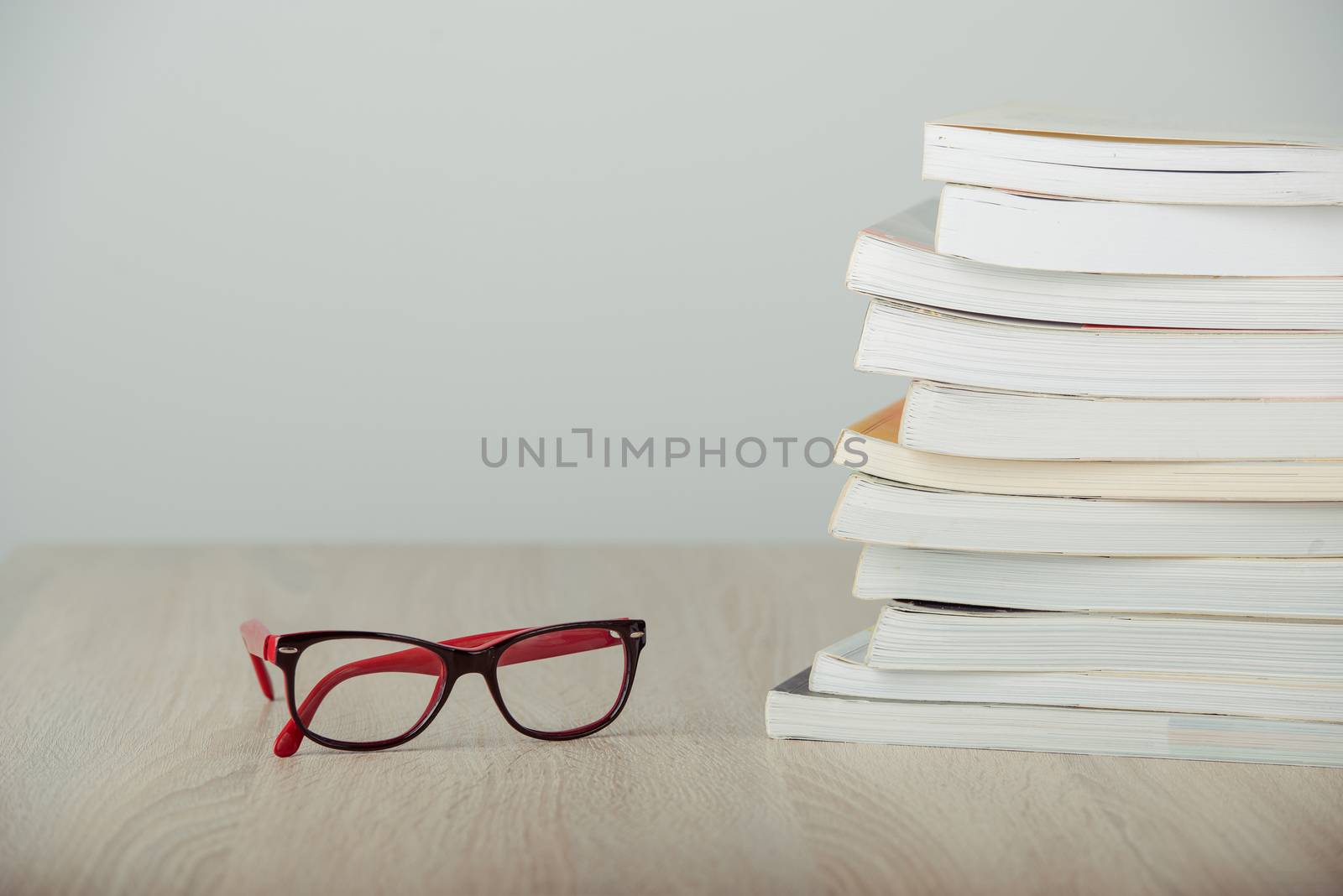 book and eyeglasses on wood background desk