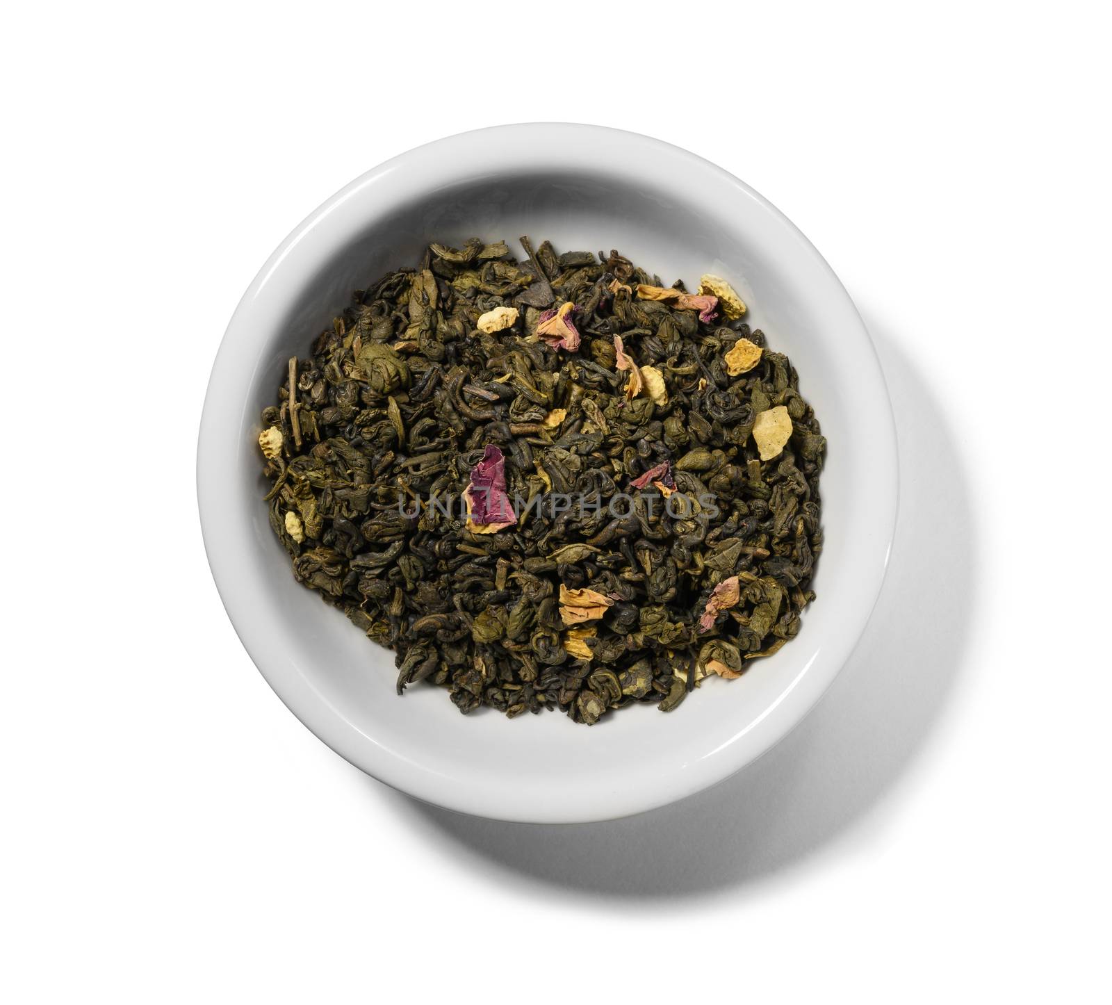 Green tea with aromatic additives. Top view on white background.
