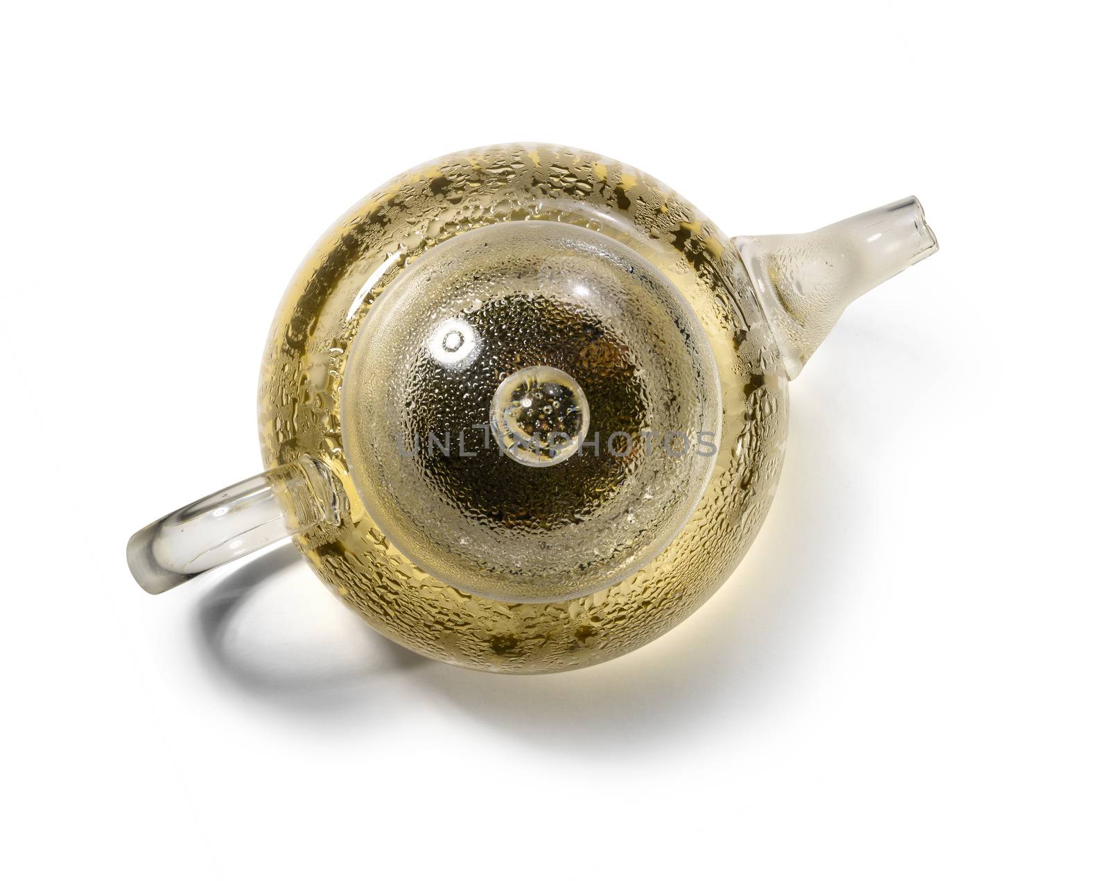 Hot green tea in glass teapot on white background.