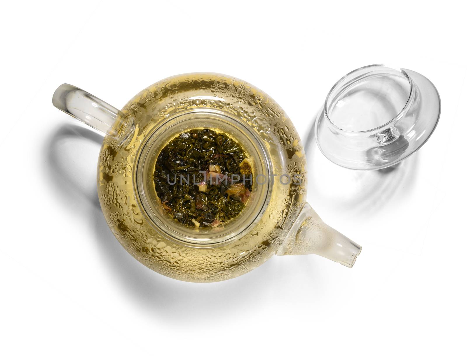Hot green tea in glass teapot on white background.