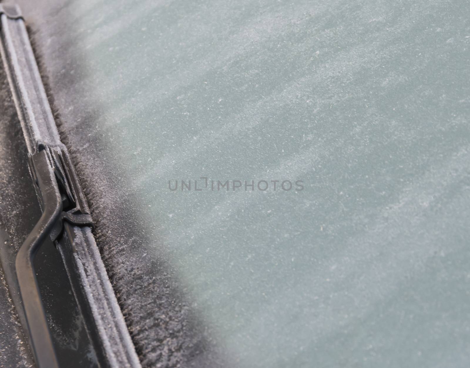 frozen windshield Close up photo and car wiper in winter. Frozen windshield of a car with ice and snow, concept of traffic. Risks in winter, copy space, selected focus