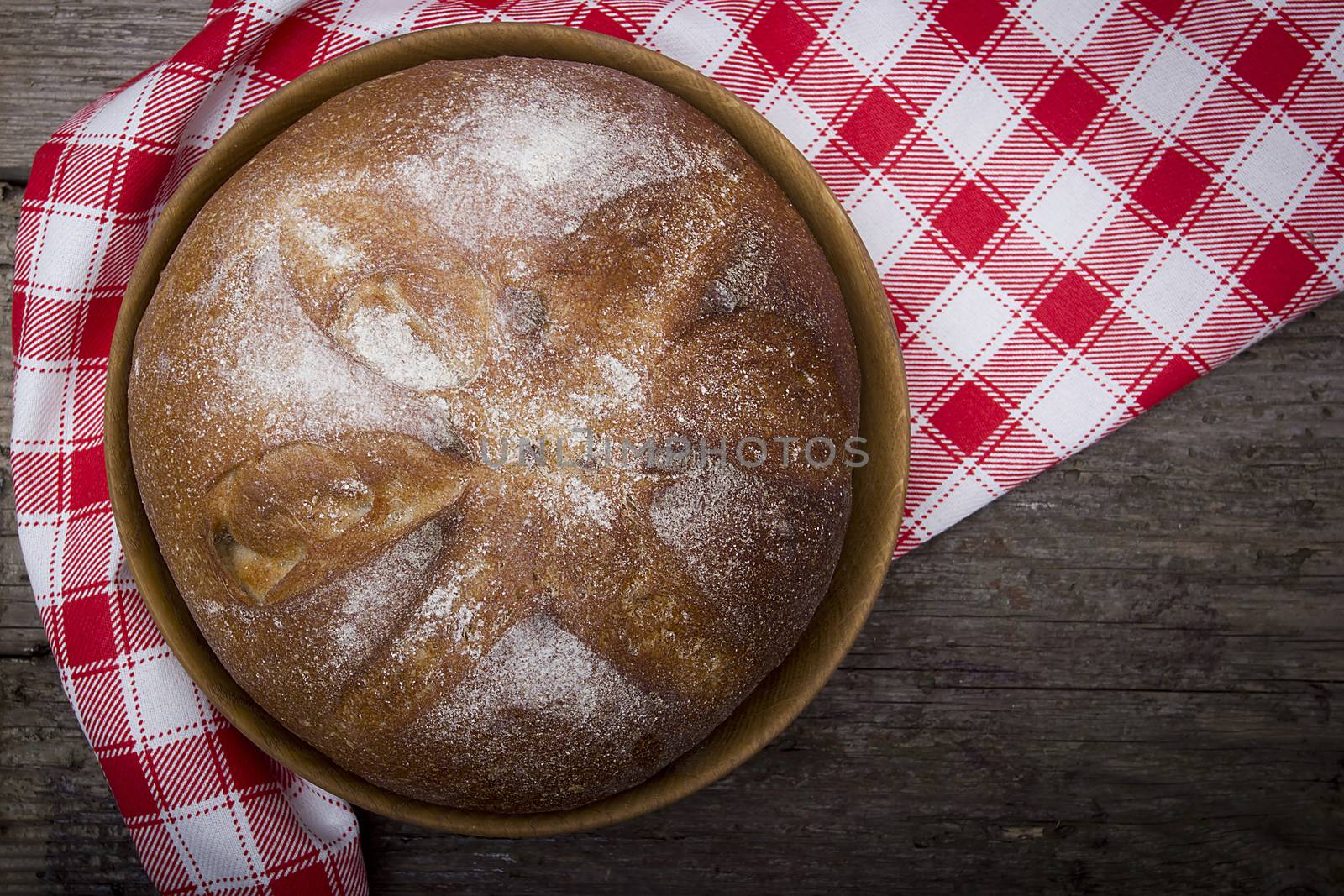 Plate with a loaf of bread on a table of old wood