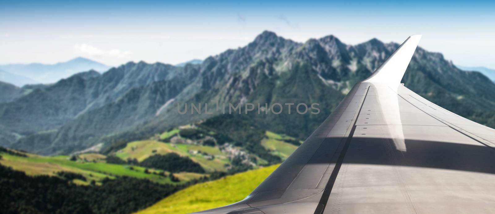 Plane flying over mountainous area by photobeps