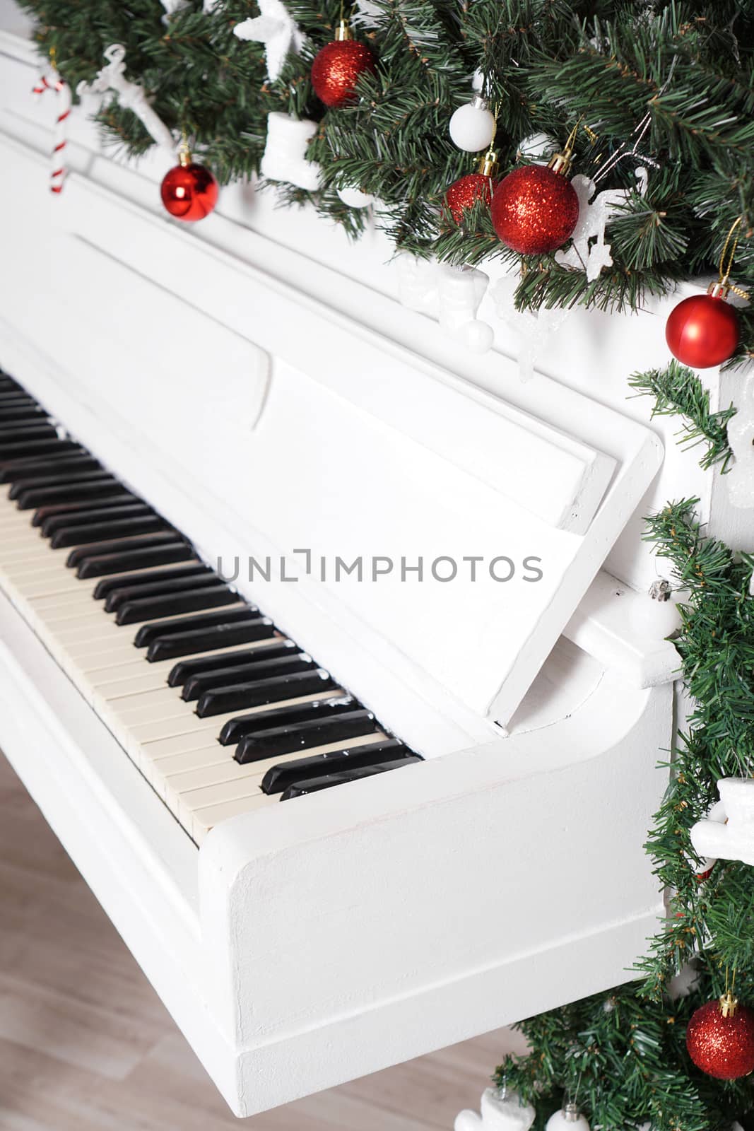 Keys on white upright piano with christmas decor with red balls