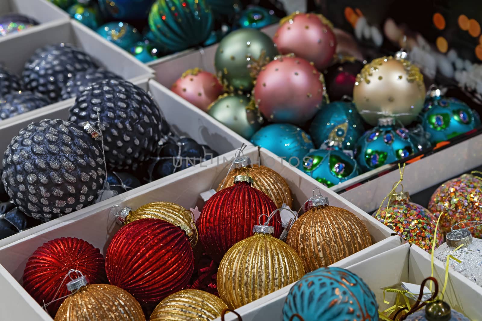 Christmas decoration. Red, yellow, blue and pink glass balls are in boxes in the store.