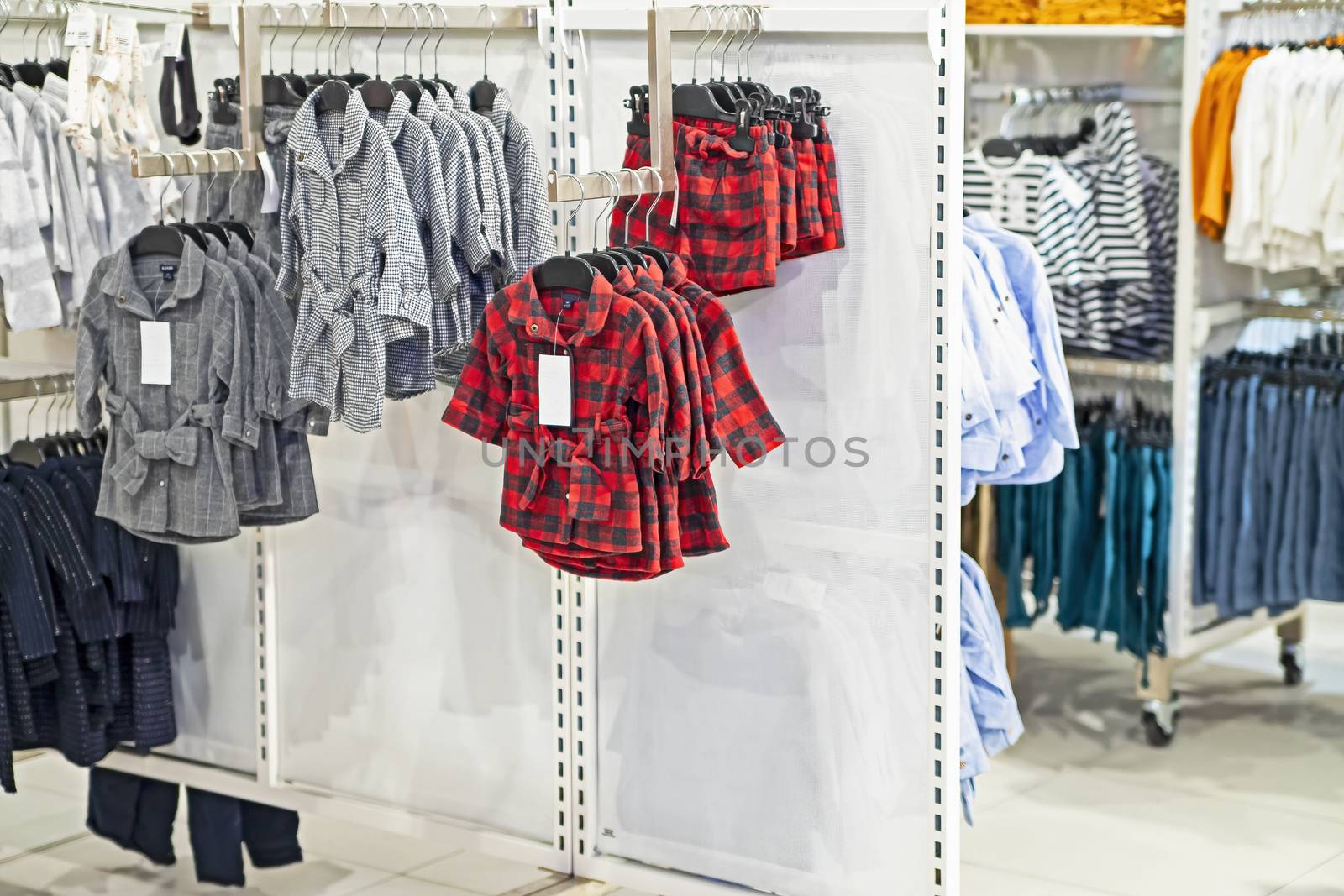 Clothes of different colors and styles hang on hangers in the children's clothing store.
