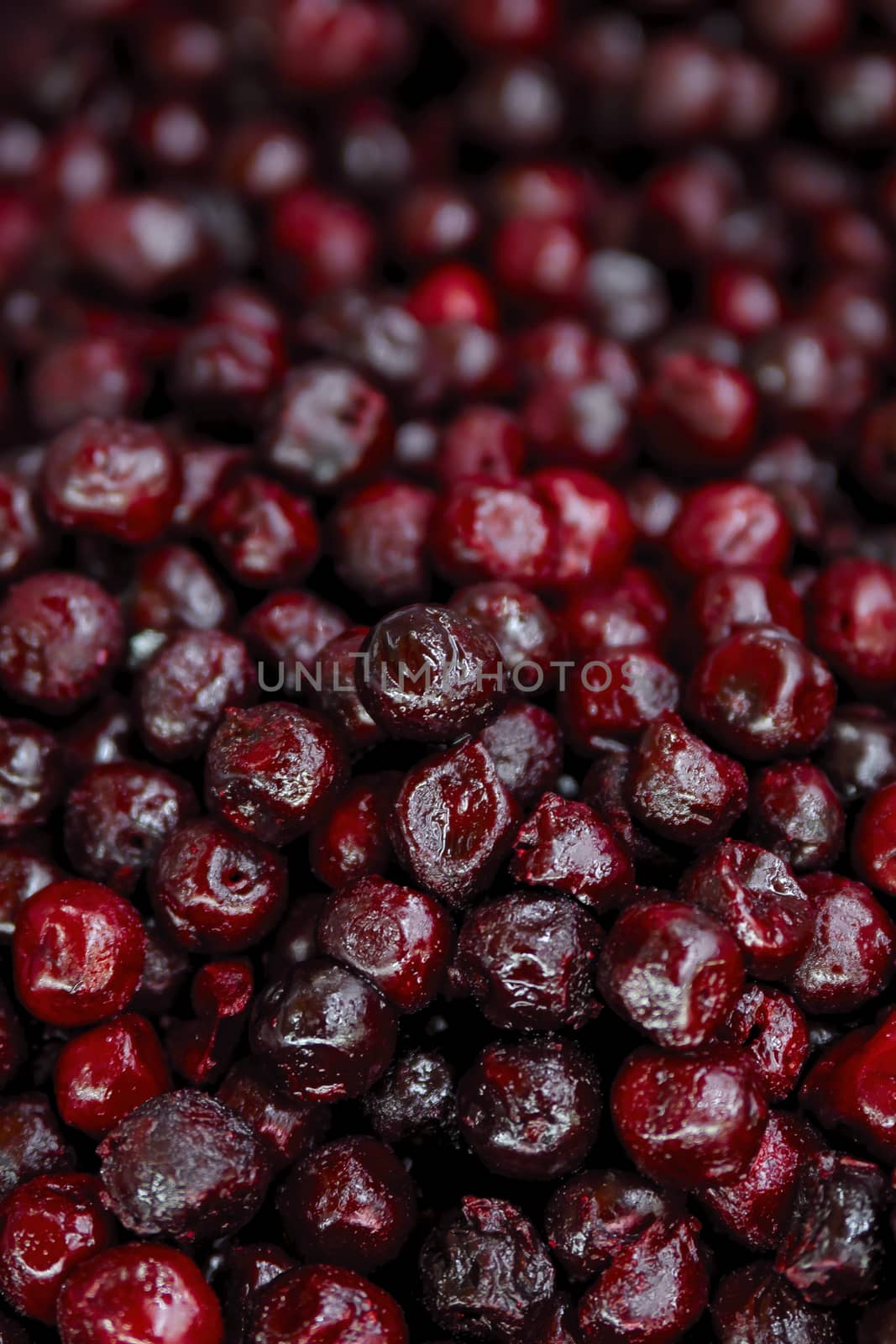 Frozen berries in grocery store shot close-up, blurred background. Dark red cherries