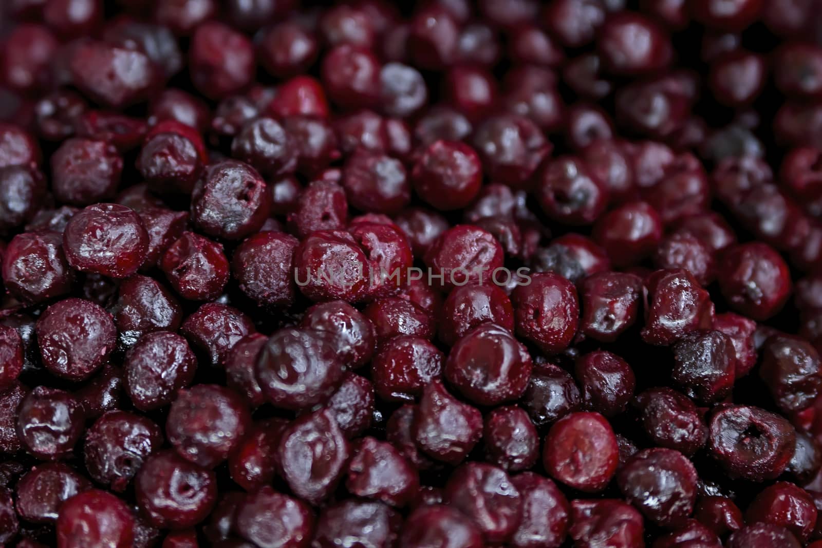 Frozen berries in grocery store shot close-up, blurred background. Dark red cherries