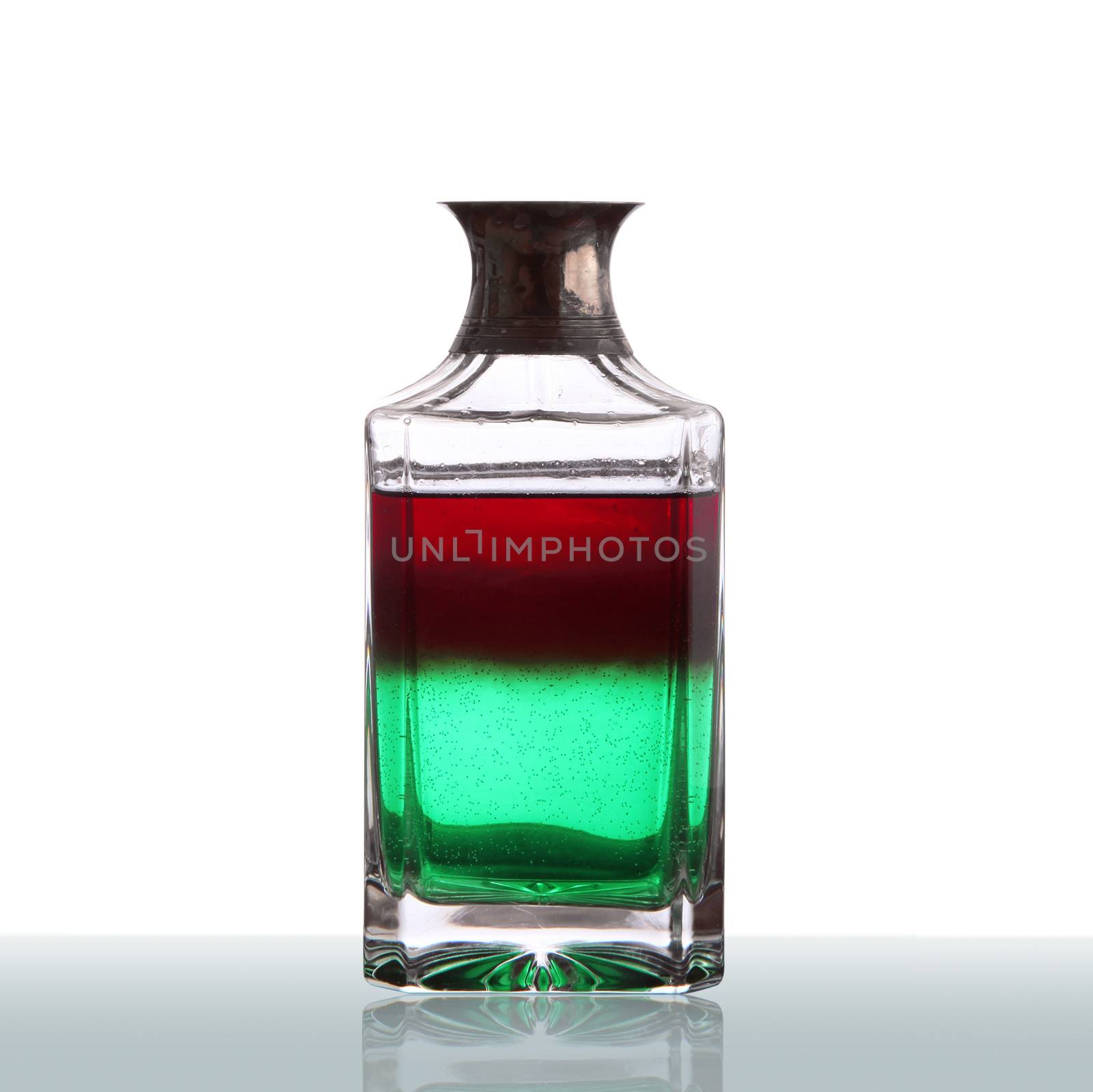 bottle with red and green liquid on white background