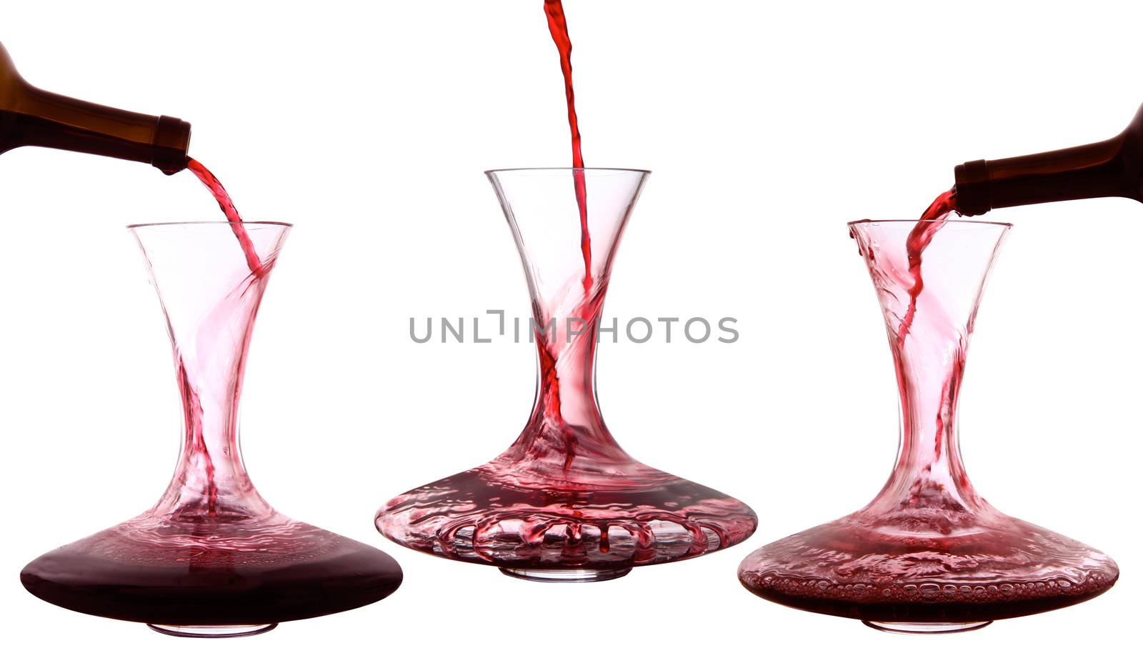 Red wine poured into decanter on white background