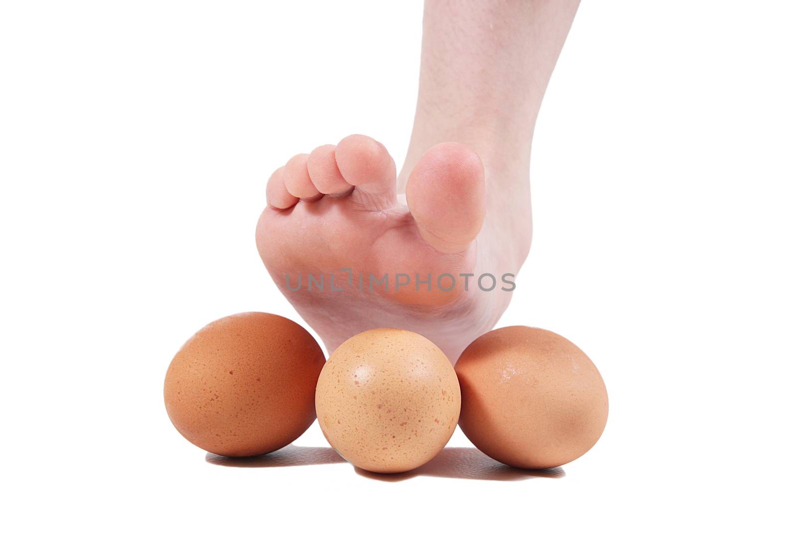 Foot crushing eggs on white background