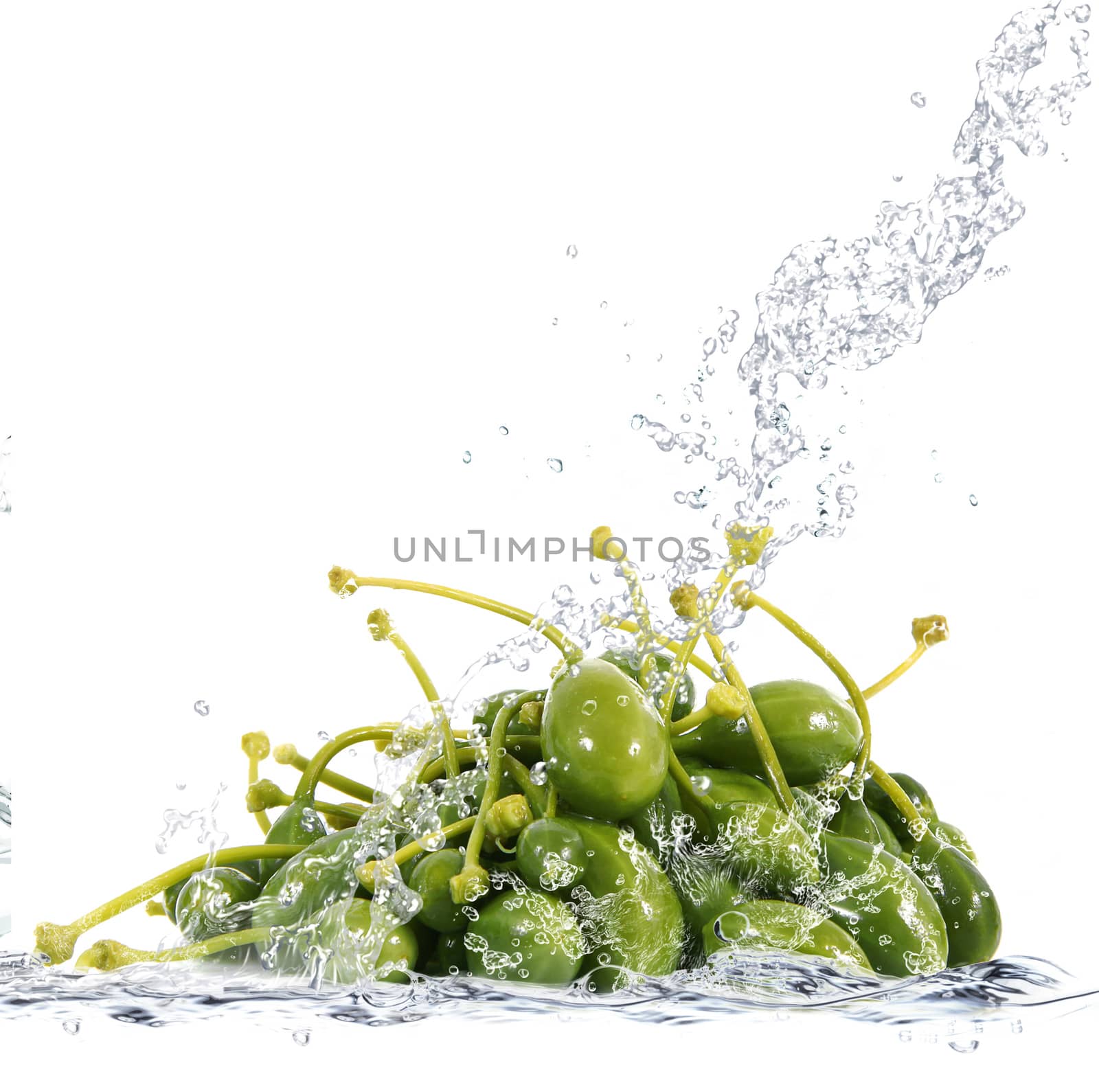 Fresh capers falling in pure water