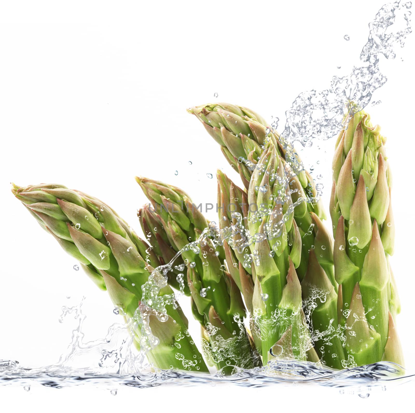Fresh asparagus falling in pure water