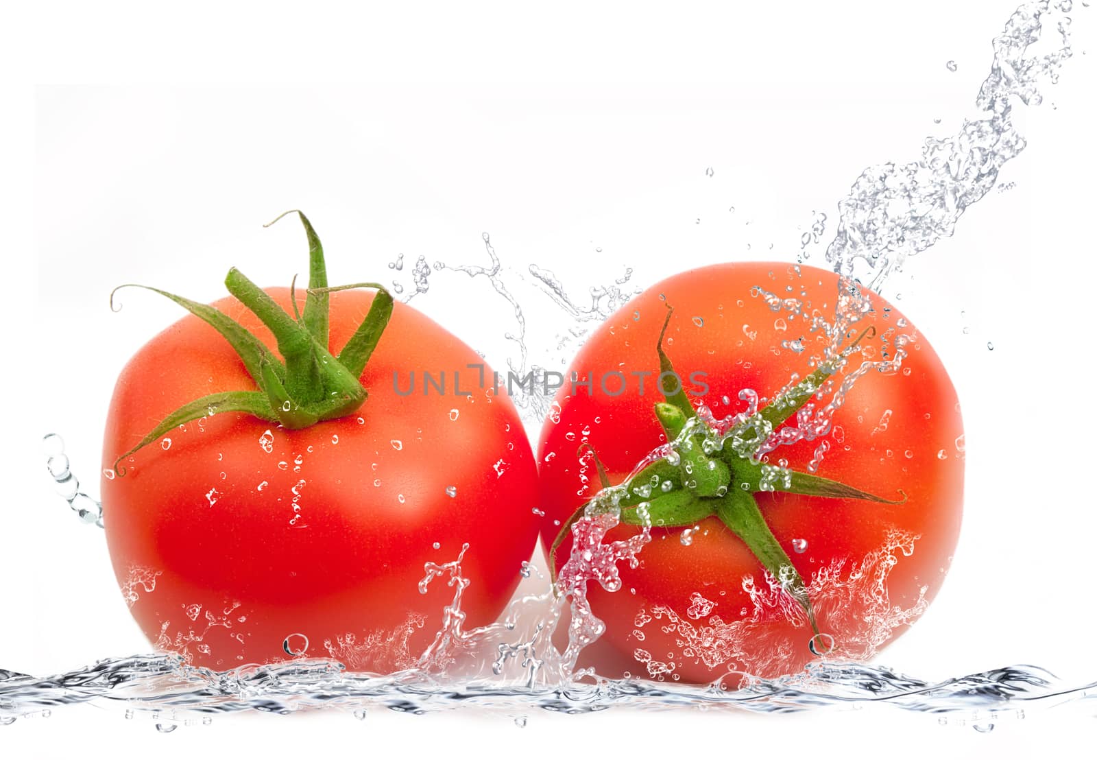 fresh tomatoes falling in pure water