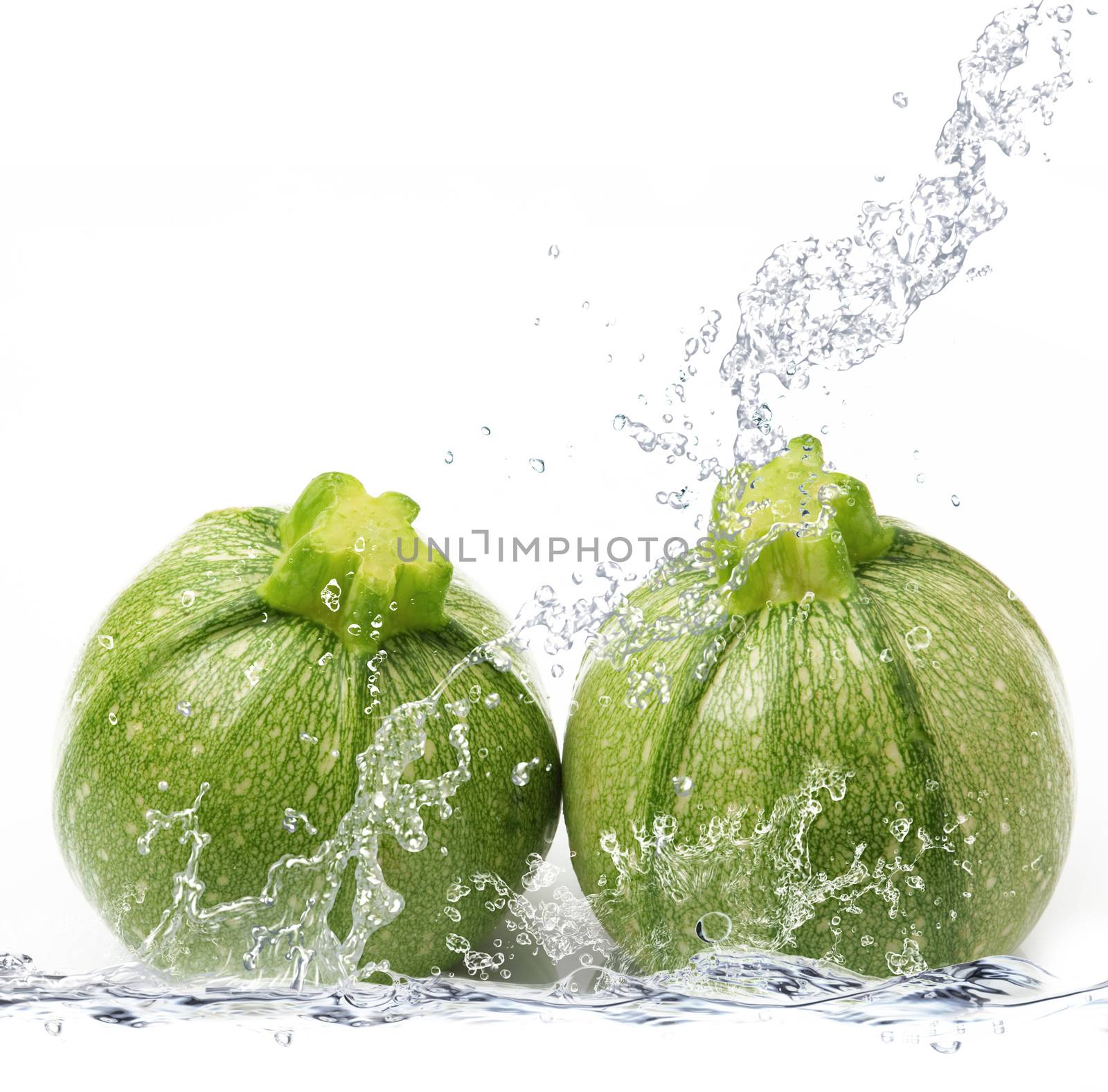 fresh courgette falling in pure water