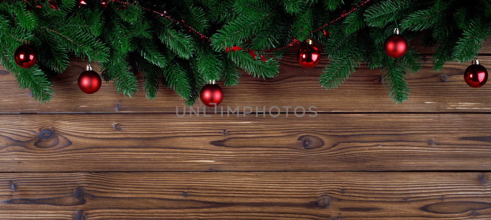 Christmas tree decoration frame on wooden background , fir tree branch , red baubles , copy space for text