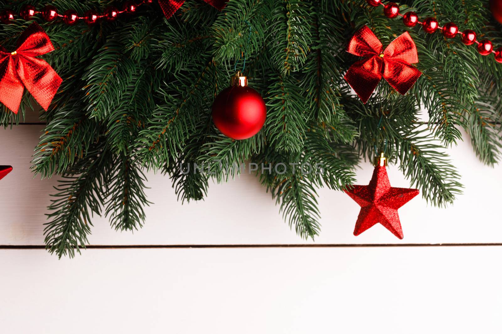Christmas tree decoration frame on wooden background, fir tree branch, red baubles