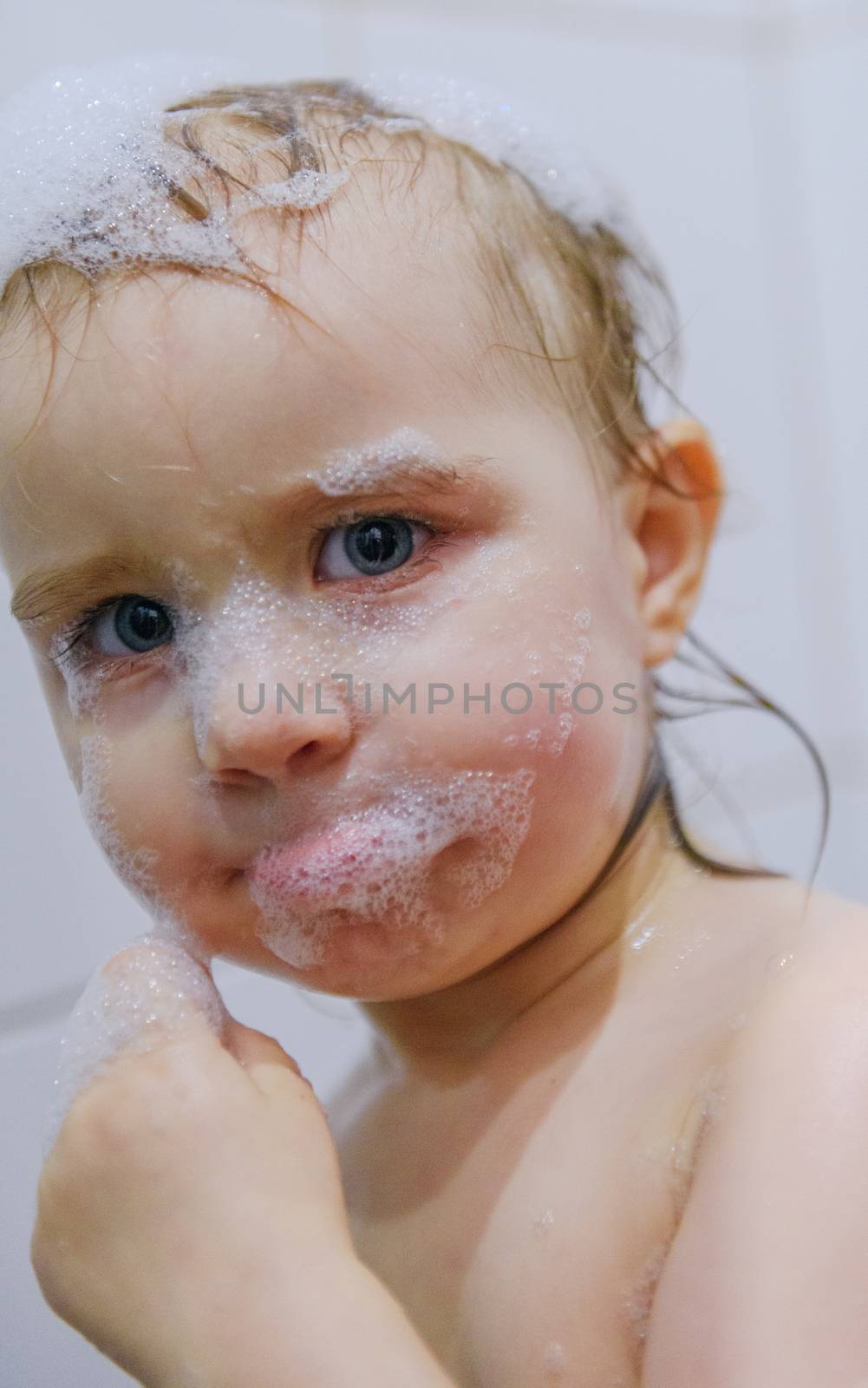 Adorable bath baby boy with soap suds on hair.