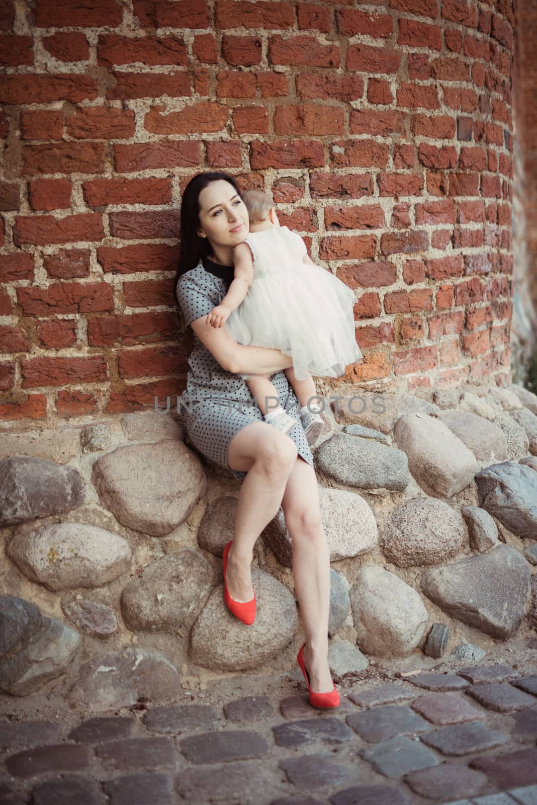 Happy mother and daughter in the park. Beauty nature scene with family outdoor lifestyle. Happy family resting together on the green grass, authentic lifestyle image