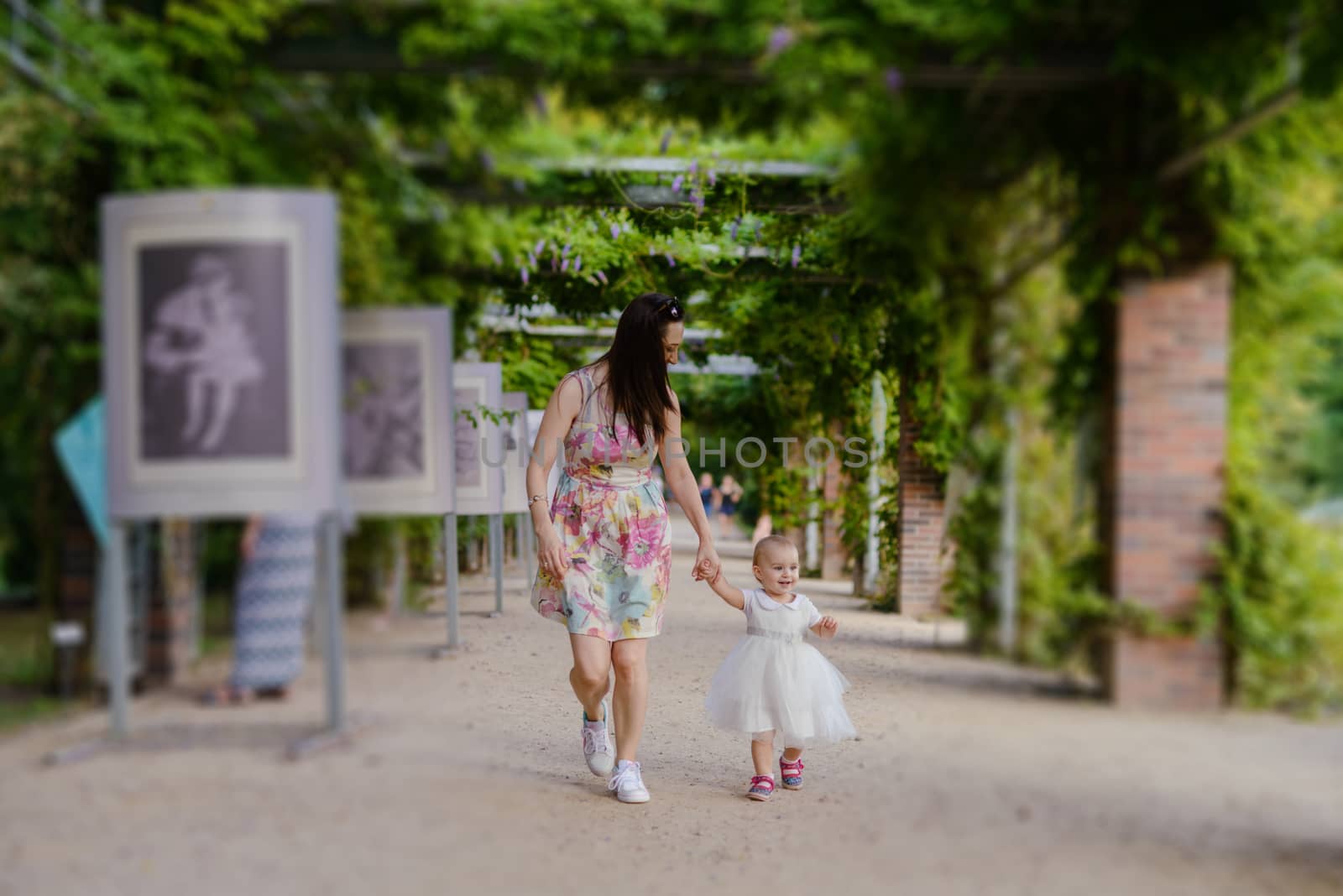 Happy mother and daughter in the park. Beauty nature scene with family outdoor lifestyle. Happy family resting together on the green grass, authentic lifestyle image
