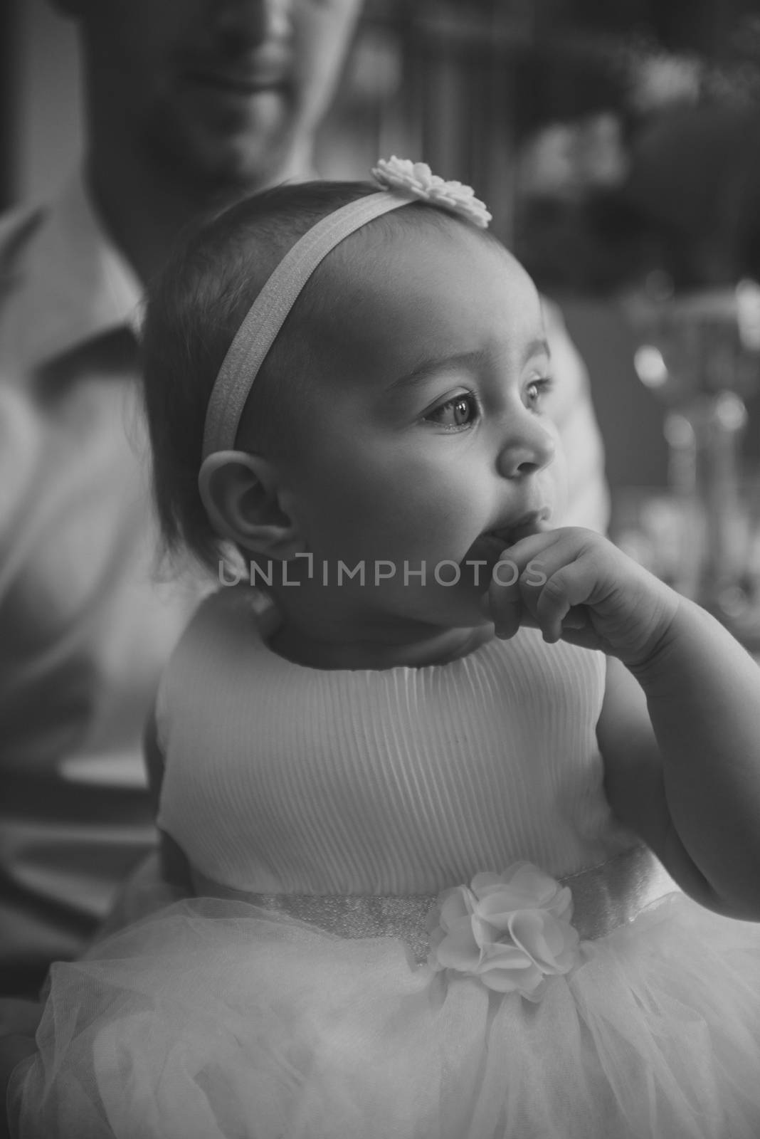 Baby girl 1 year old eating birthday cake in room. Birthday party. Childhood.