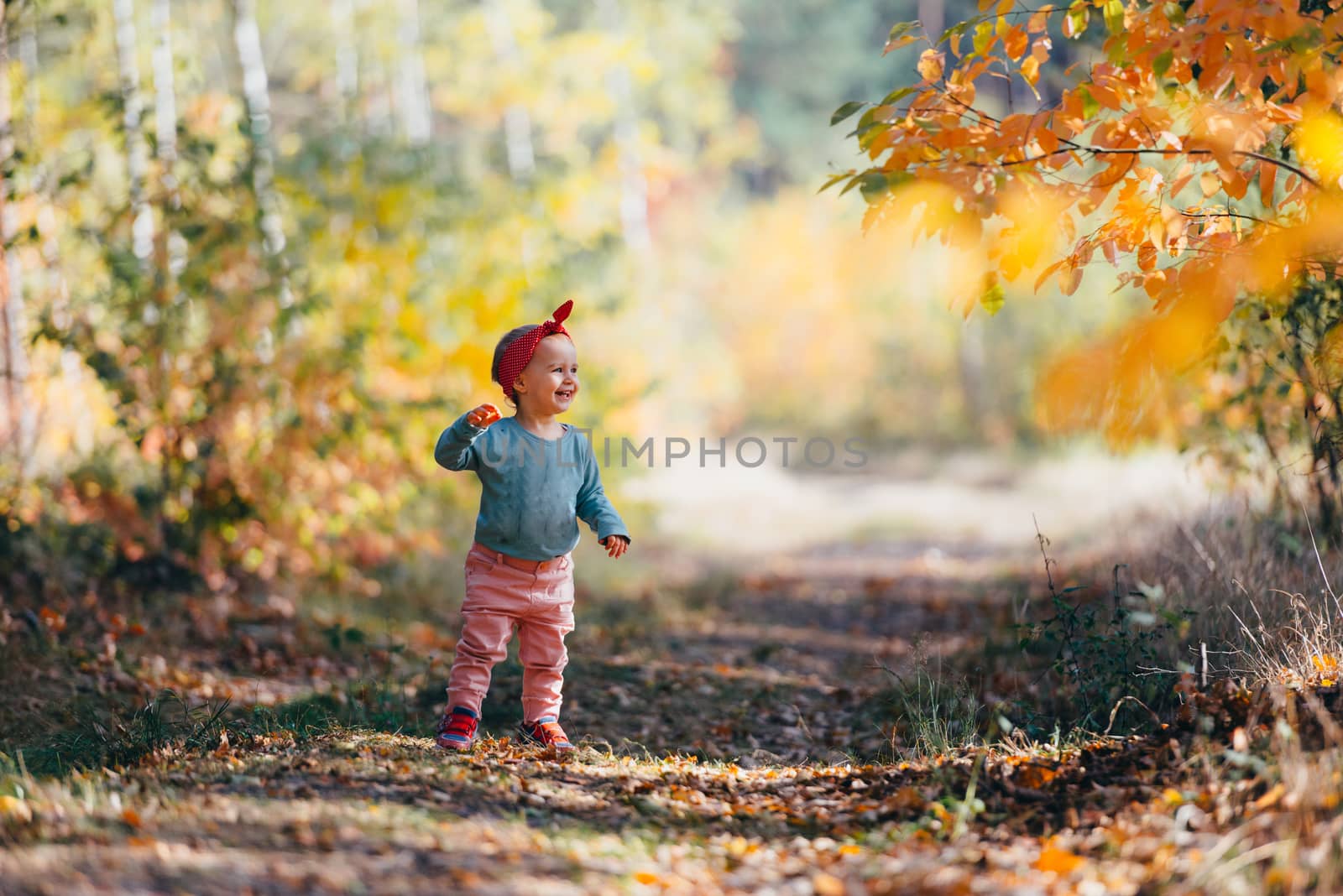 Adorable girl having fun on beautiful autumn day. Authentic picture.