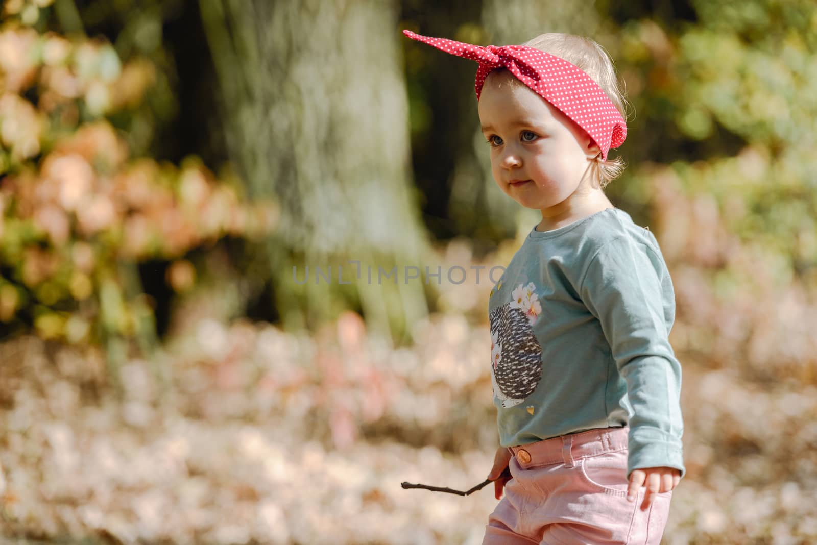 Adorable girl having fun on beautiful autumn day. Authentic picture.