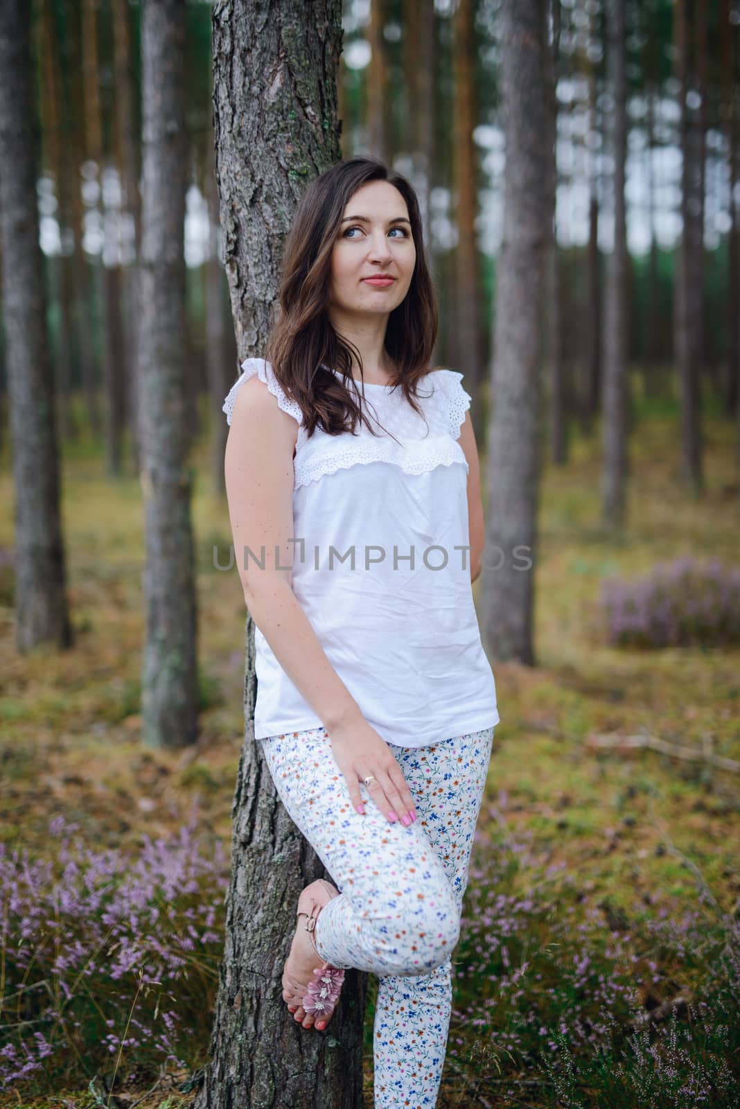 Woman in the forest where the purple heather blooms. copy space. Authentic lifestyle image. by Brejeq