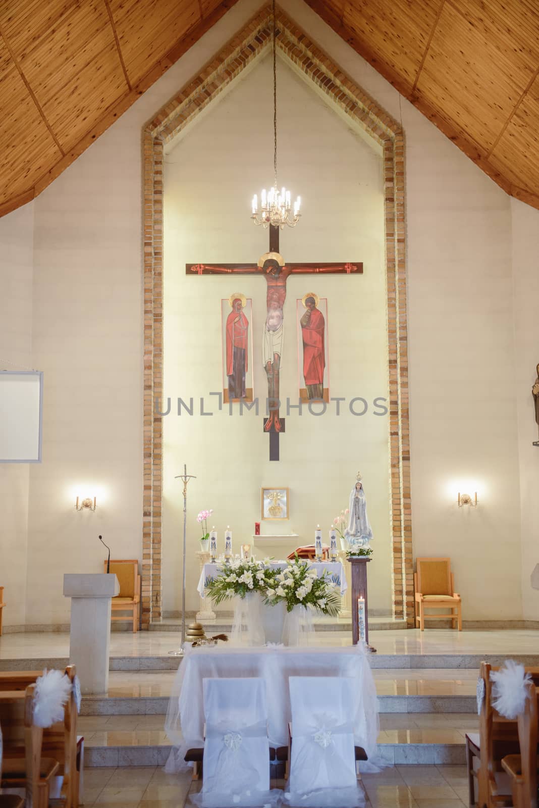 Church sanctuary before a wedding ceremony. Empty chairs for bride and groom