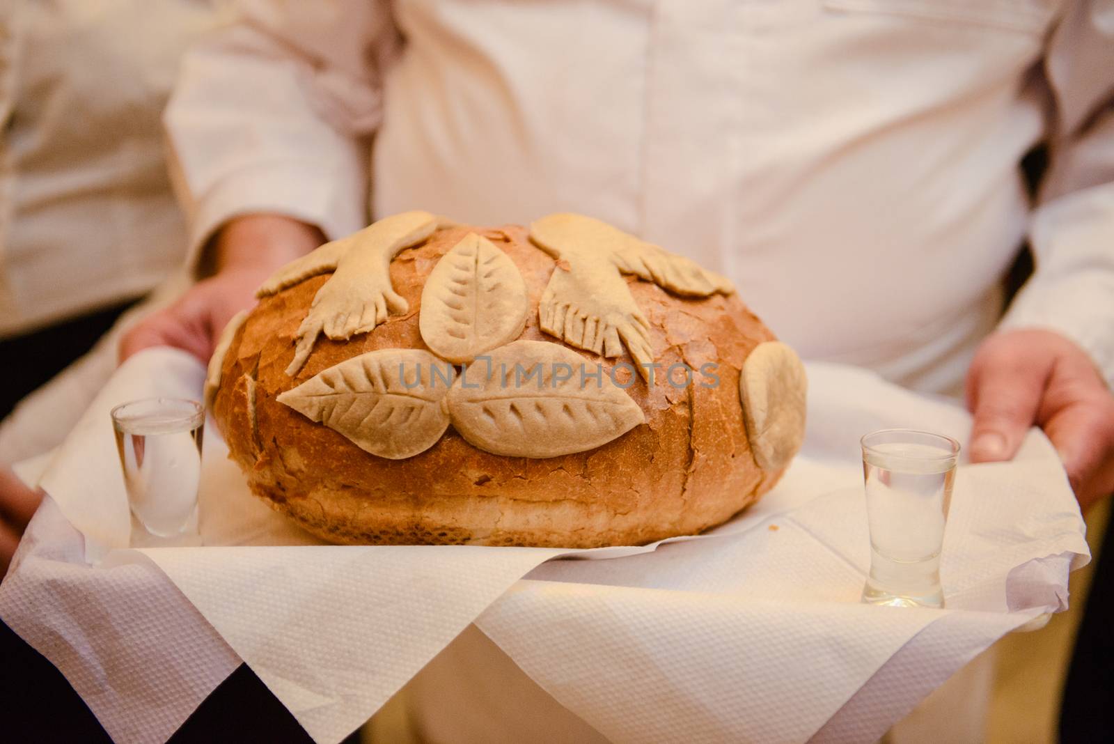 Traditional polish greeting the bride and groom by the parents with bread and salt. Vodka also in glasses.