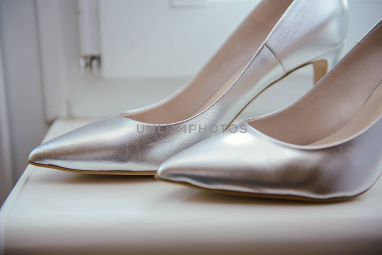 The bride shows white wedding shoes. Wedding detail. Close up