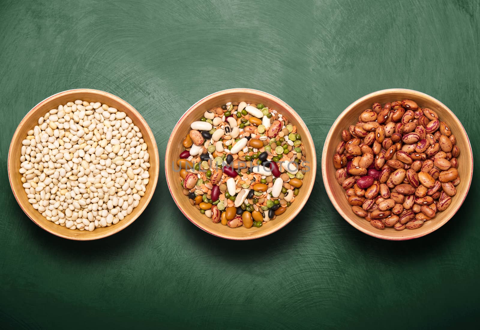 bowls with beans on green background