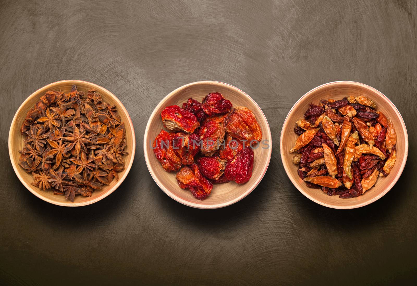 bowls with anise star and dry pepper on dark background