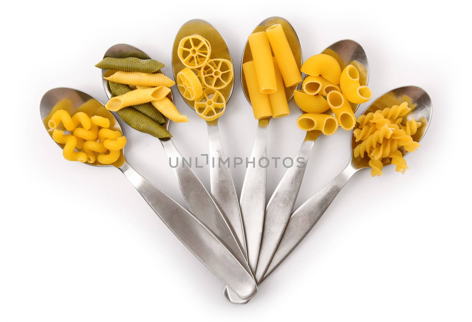 spoons with italian raw pasta on white background