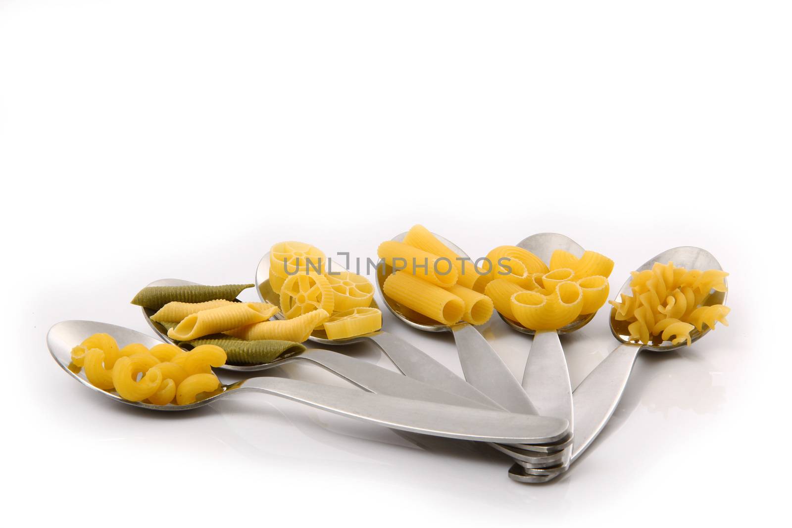 spoons with italian raw pasta on white background