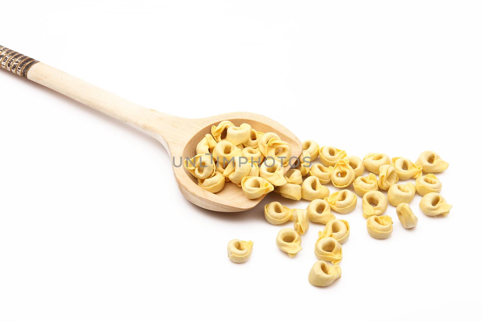 wood spoon with italian raw pasta on white background