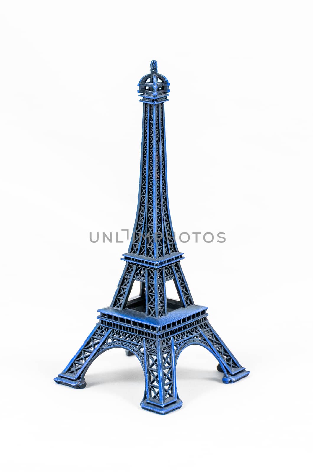 Close up shot of a blue miniature model of the Eiffel Tower isolated on a white background