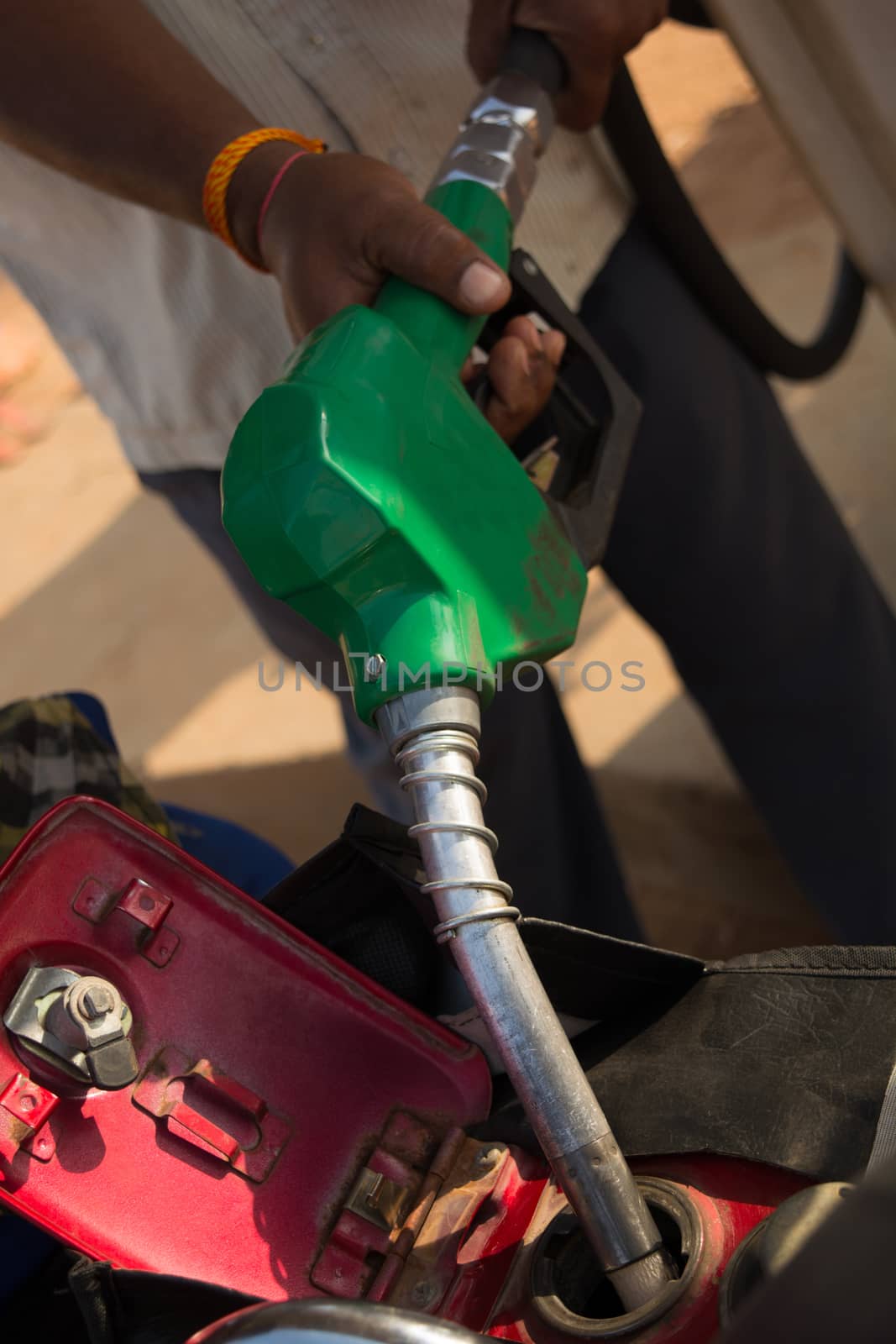 Person filling the Petrol using oil dispenser to bike petrol tank close up