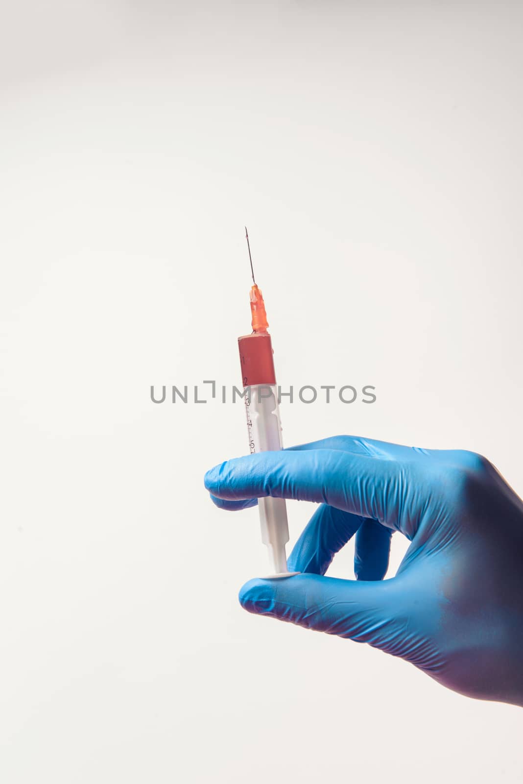 Hand in glove with syringe on white background. Injections.