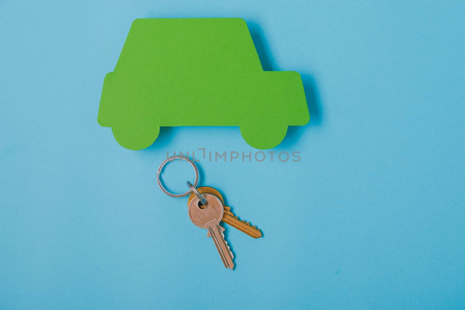 paper green cars figure with keys. top view on blue background
